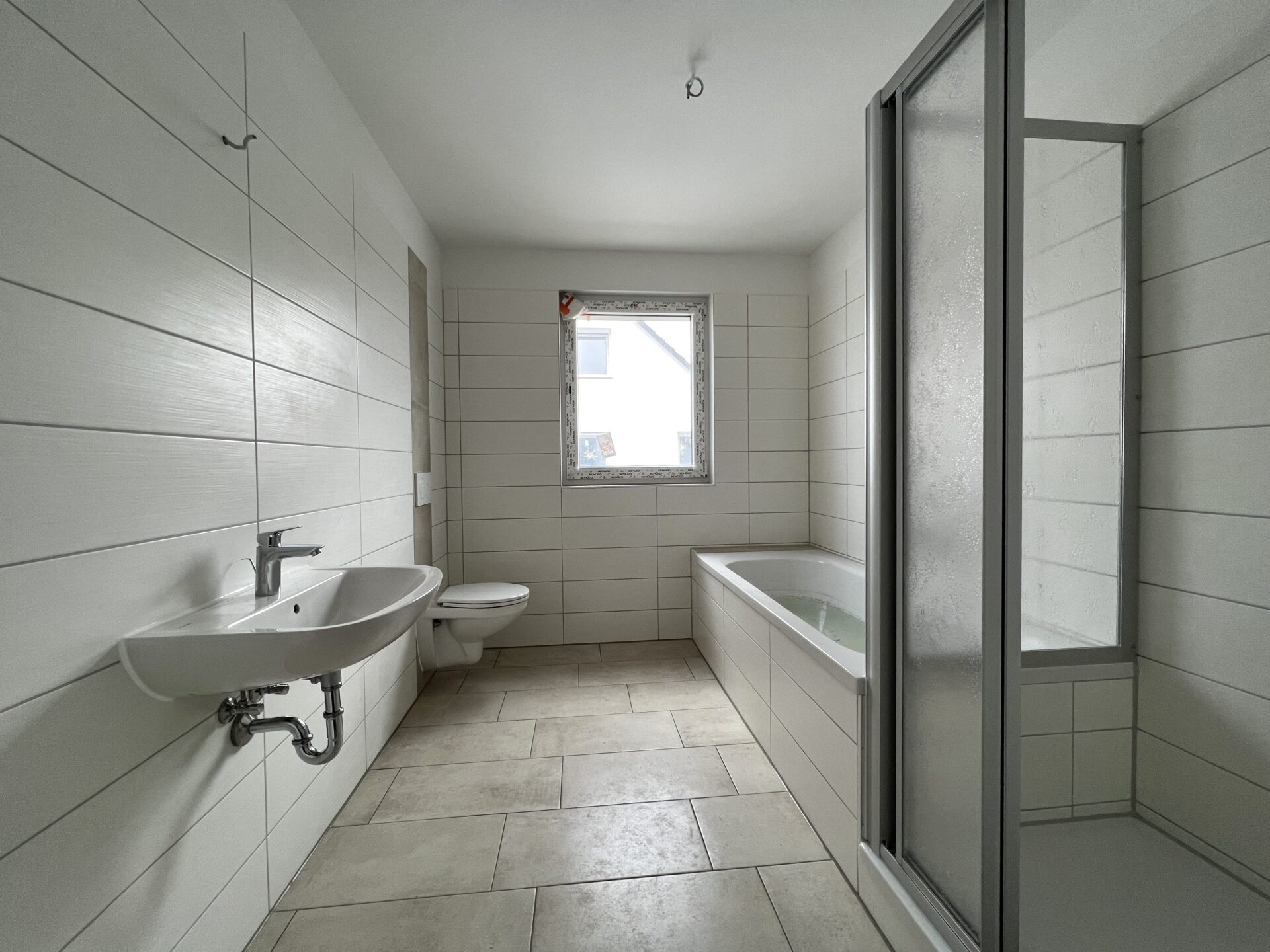 Tageslichtbad mit Badewanne und Dusche - Musterwohnung