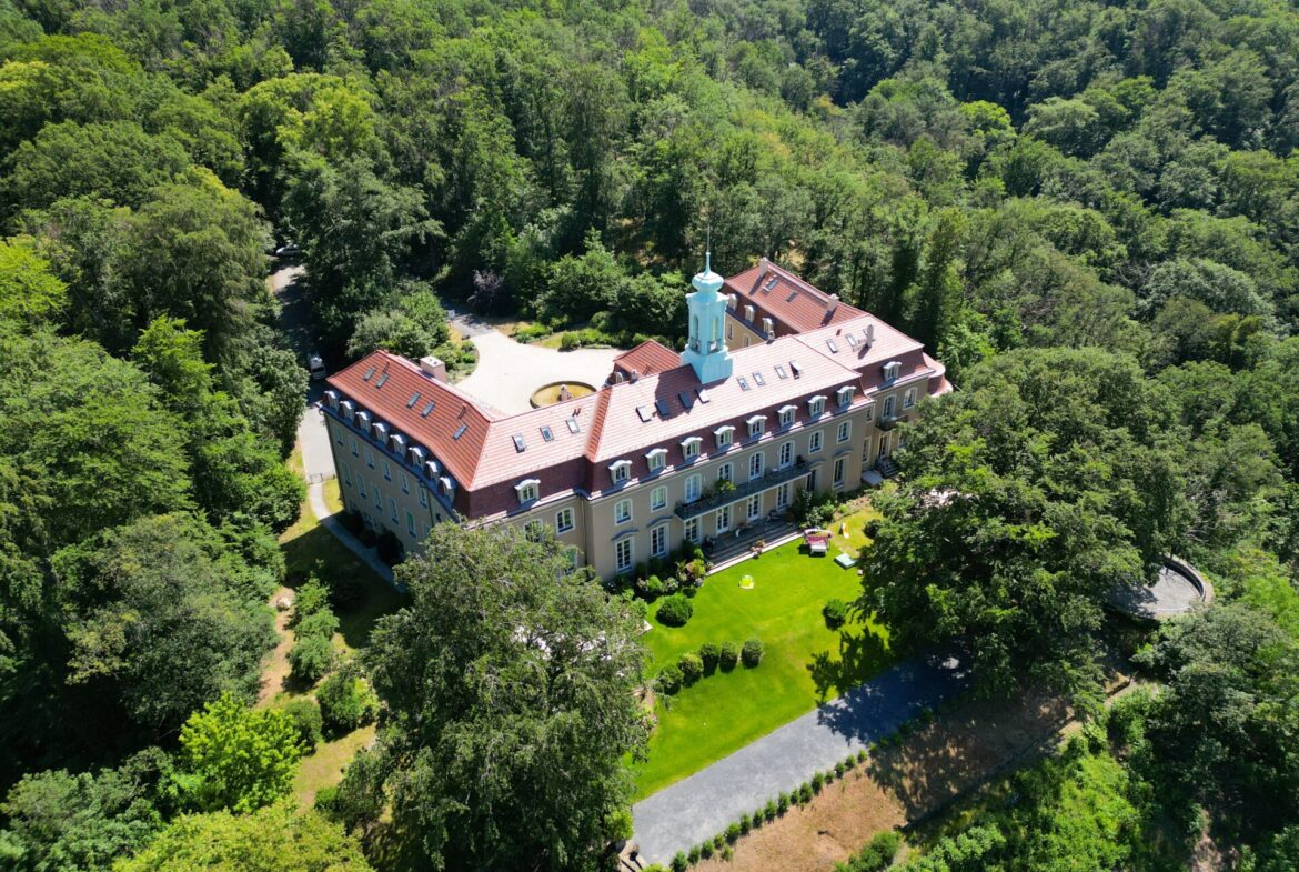 Schlossansicht mit angrenzenden Gartenabteilen