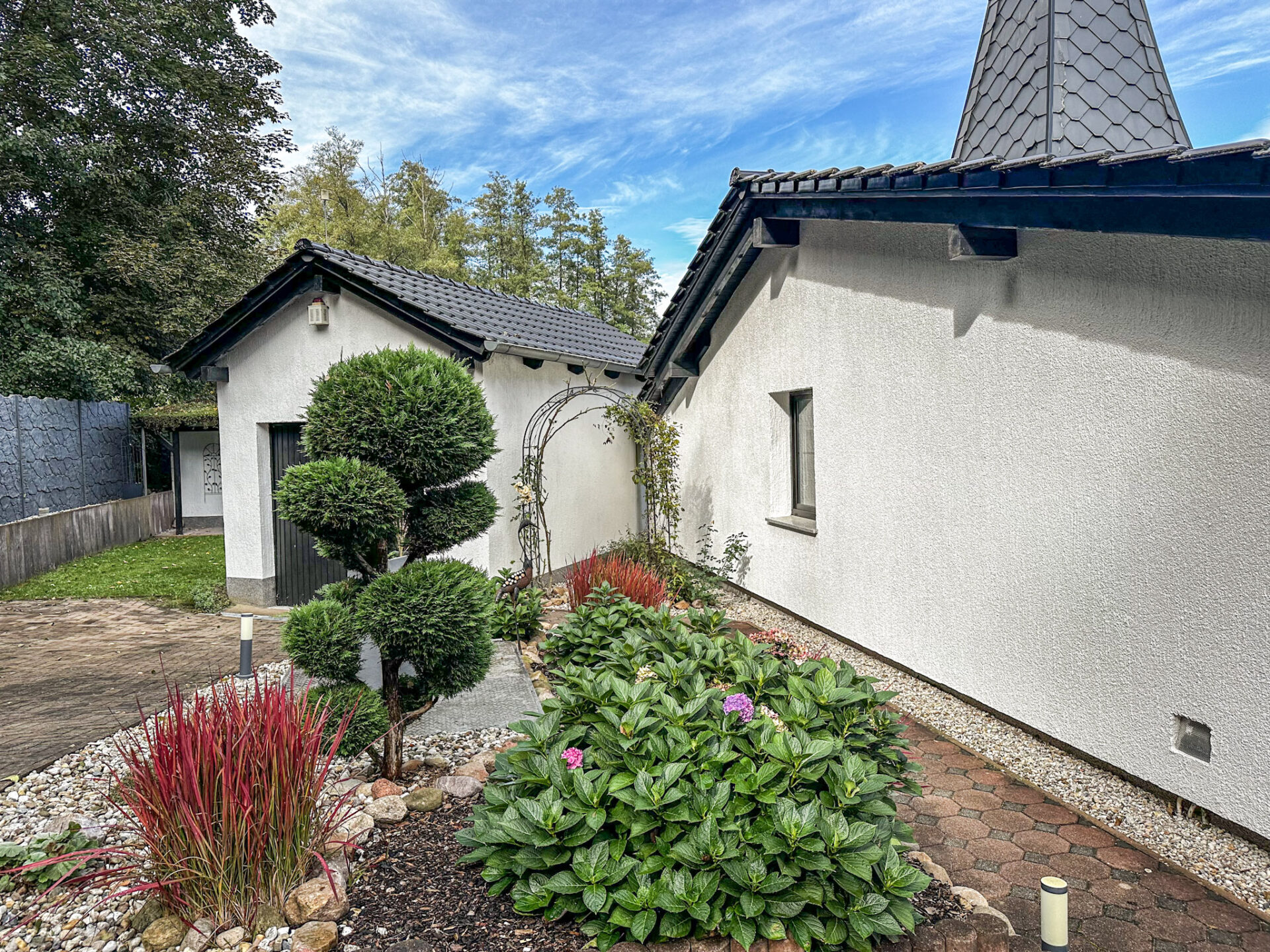 Weg zur Garage durch den Rosenbogen