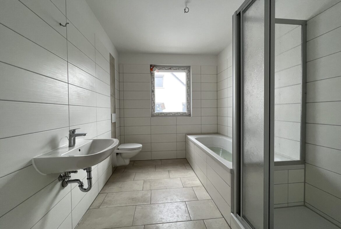 Tageslichtbad mit Badewanne und Dusche - Musterwohnung