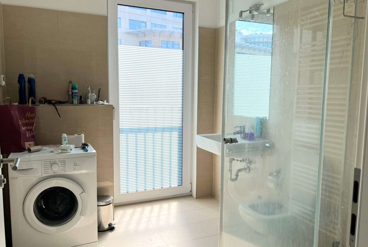 Modernes Badezimmer mit ebenerdiger Dusche, Waschmaschine und französischem Balkon