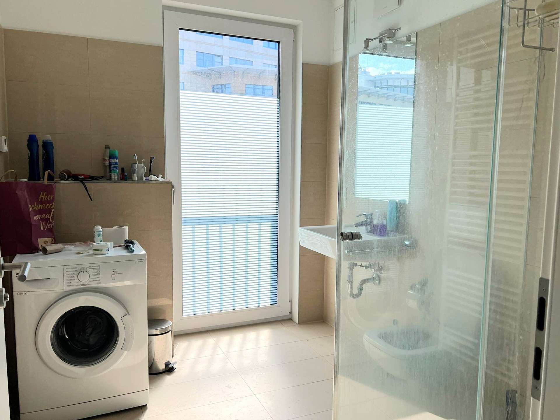 Modernes Badezimmer mit ebenerdiger Dusche, Waschmaschine und französischem Balkon