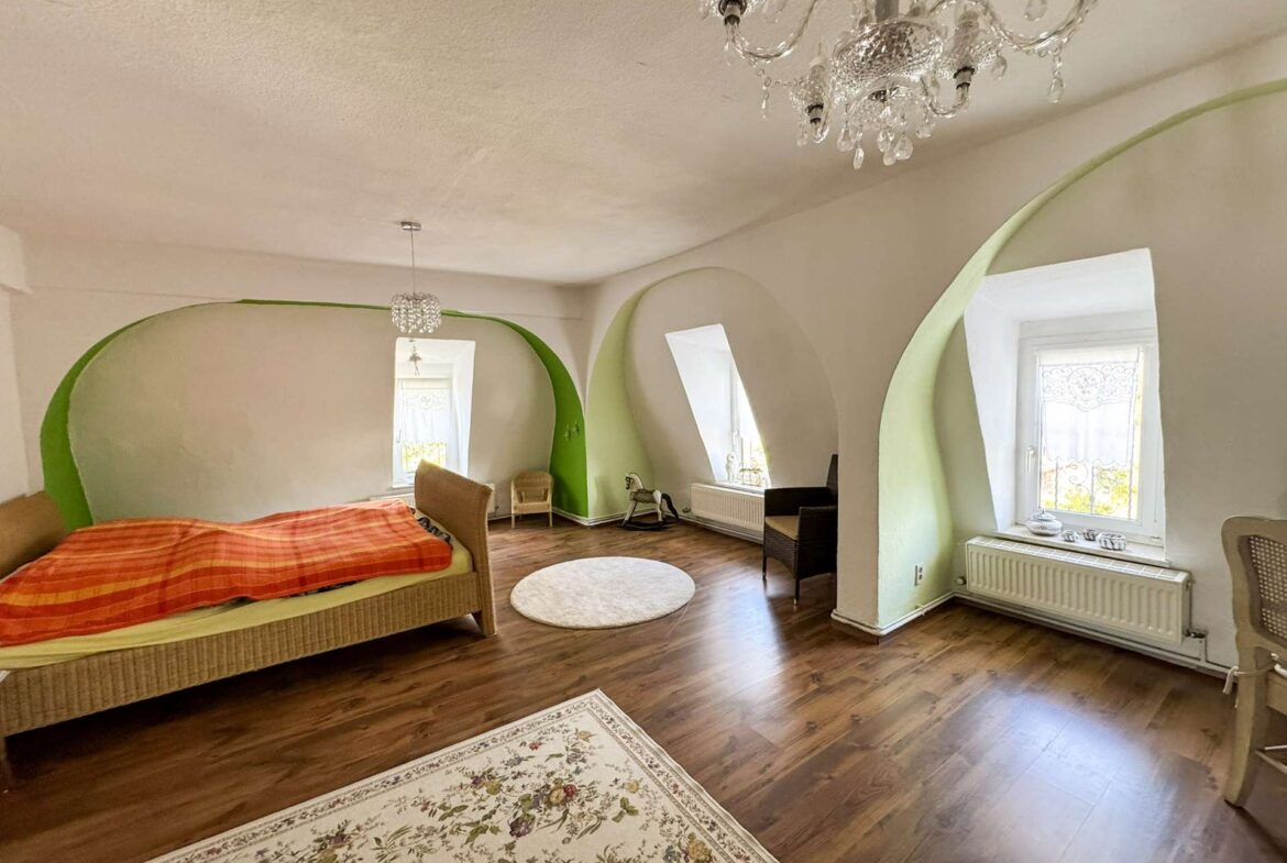 Schlafzimmer mit Nischenfenstern und Kronleuchter