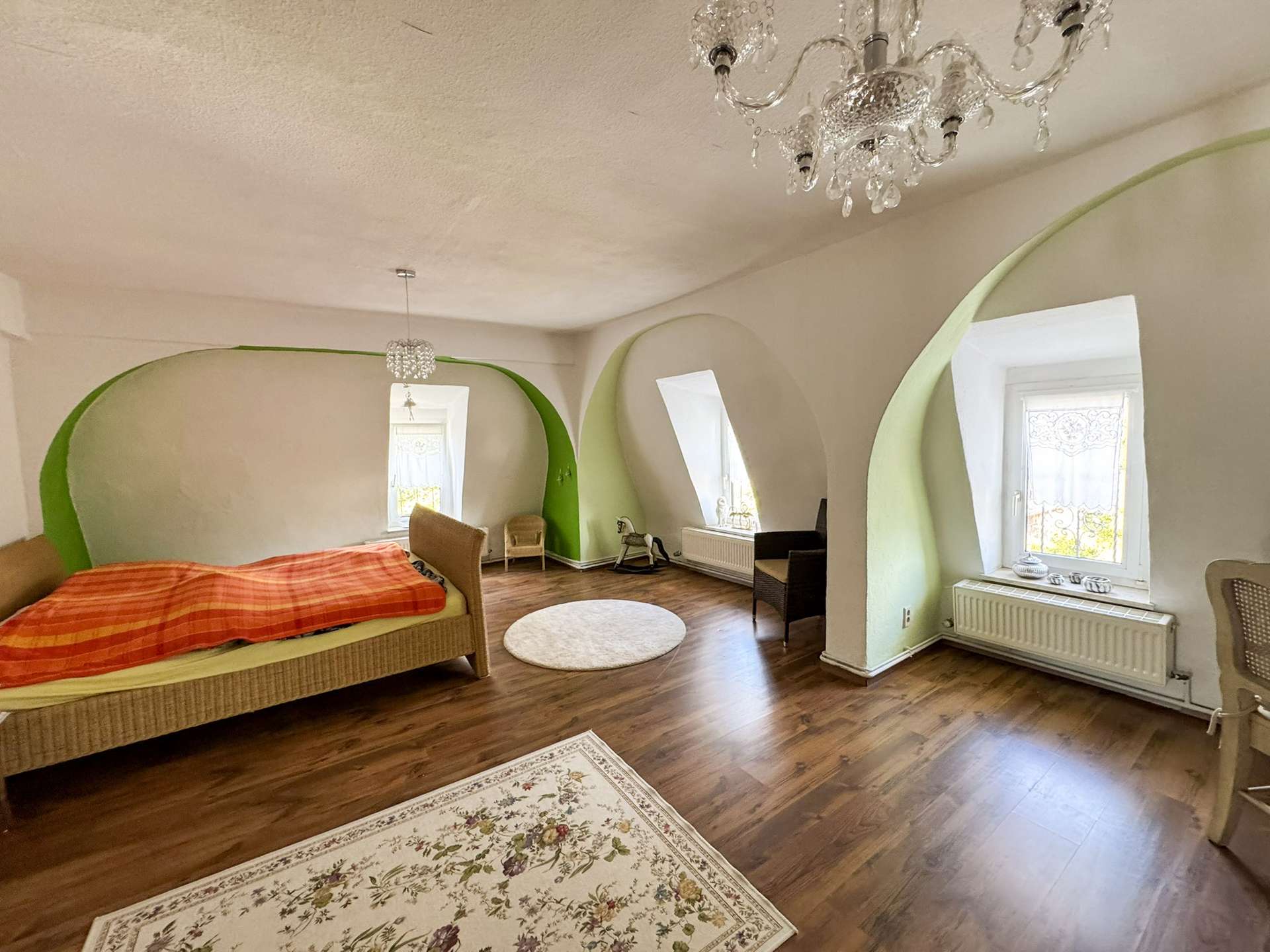 Schlafzimmer mit Nischenfenstern und Kronleuchter