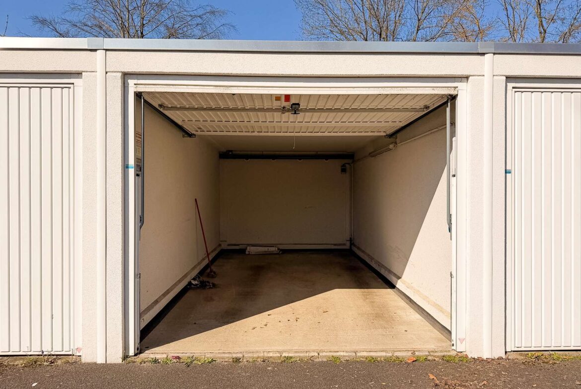 Open storage unit with white walls and a bare interior, blue sky visible above.