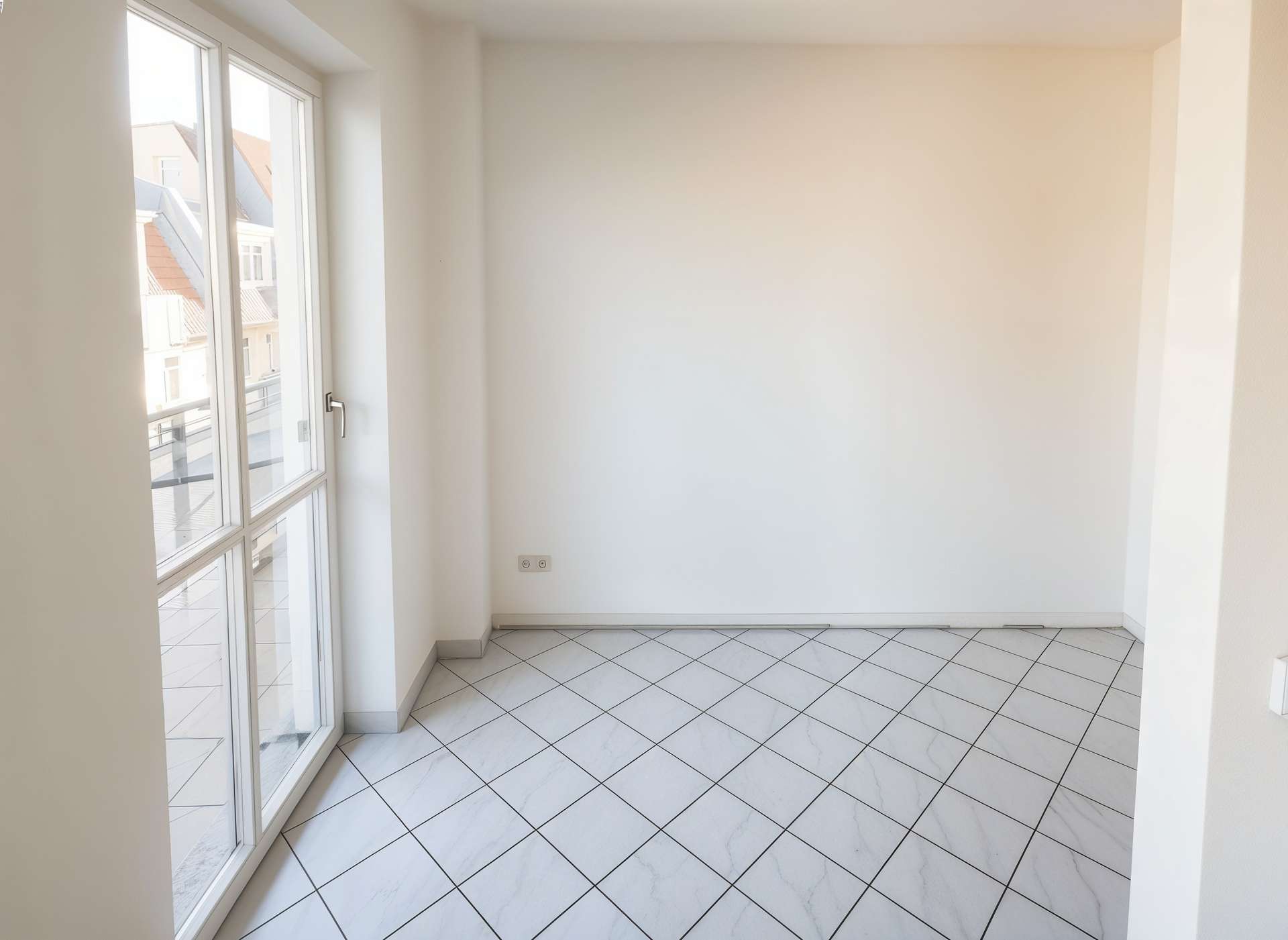 Bright empty room with large glass door/windows on the left leading to a balcony, white walls, and tiled floor in daylight.