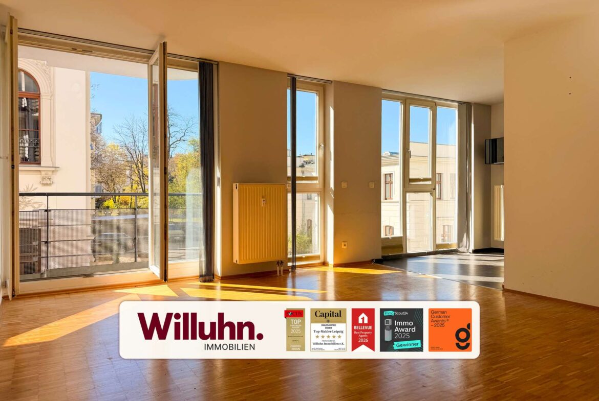 Sunlit empty living room with tall glass doors opening to a balcony and an advertising banner for Willuhn Immobilien at the bottom.