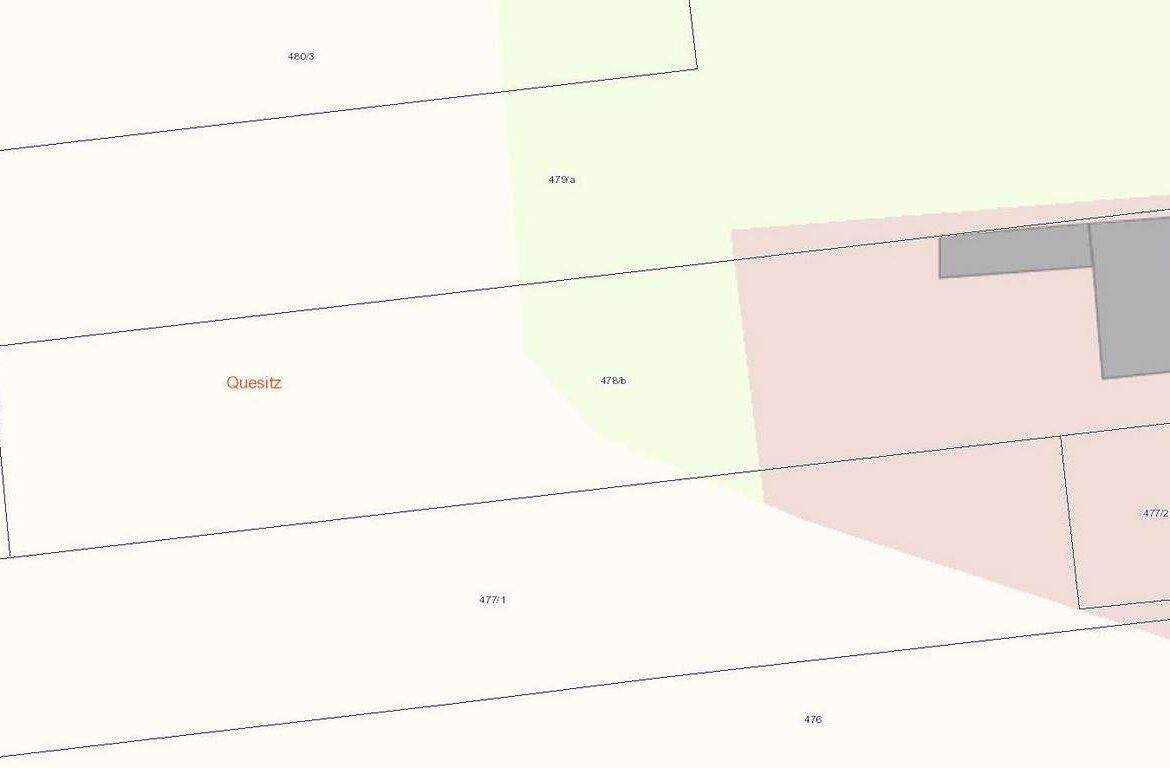 Cadastral map of property parcels with boundary lines; a light green area and a pink area indicating different land uses, plus a gray building footprint on the right side.