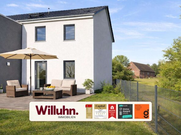 Modern white two-story house with a wooden deck, beige outdoor furniture, and a large umbrella; foreground shows a Willuhn Immobilien banner.