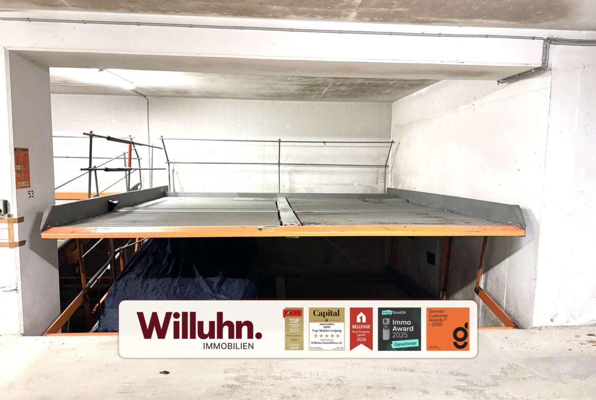 Construction site interior with metal scaffolding and a large Willuhn Immobilien banner in the foreground.