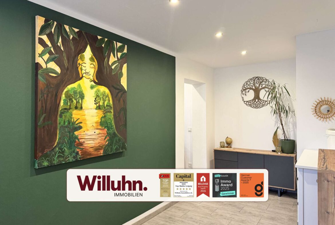 Interior showroom with a large forest-themed painting on a dark green wall above a light-colored floor and counter area.