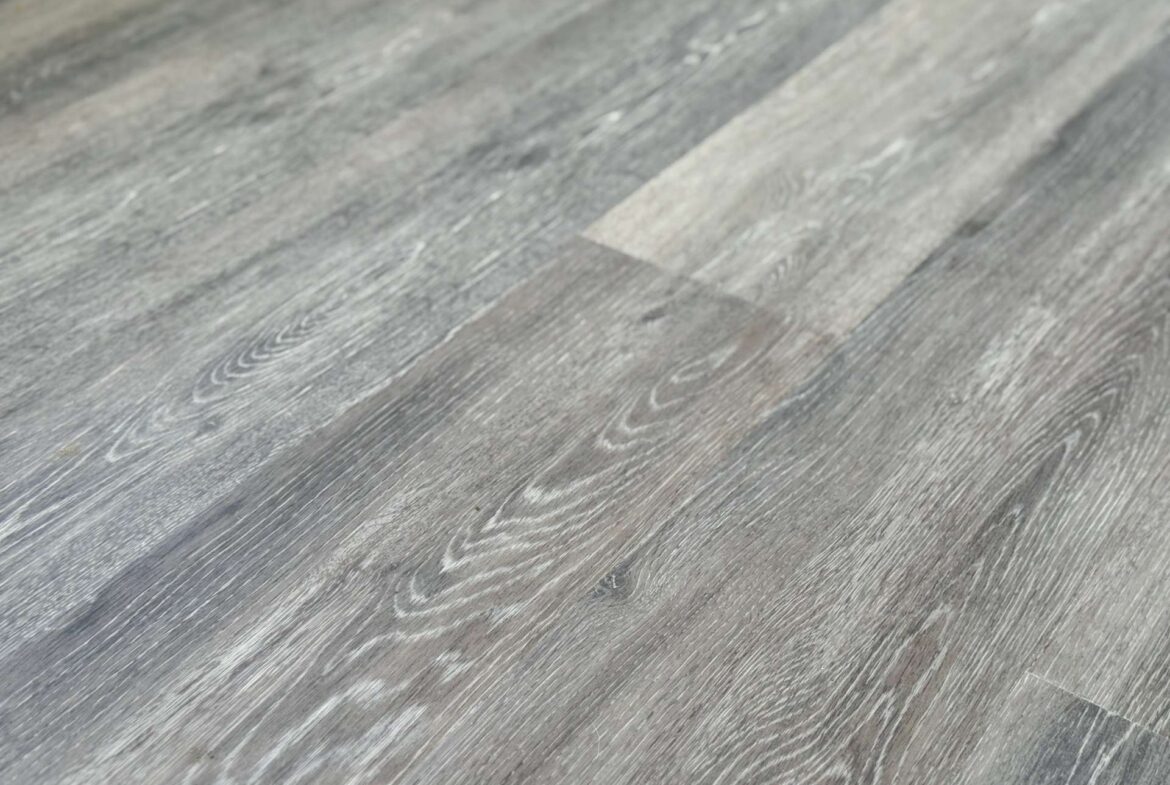 Close-up of weathered gray wooden floorboards with visible grain patterns and subtle scratches.