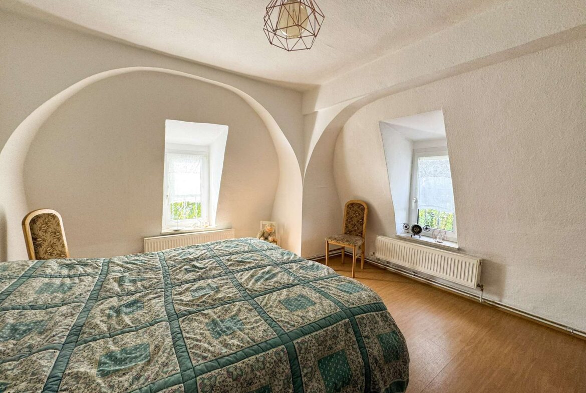 Gemütliches Schlafzimmer mit zwei Fenstern