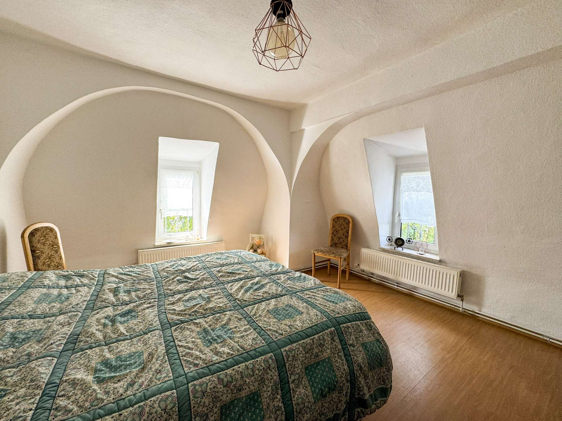 Gemütliches Schlafzimmer mit zwei Fenstern