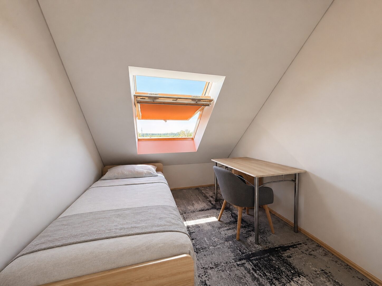 Small attic bedroom with a single bed on the left and a desk on the right beneath a skylight with an orange shade.