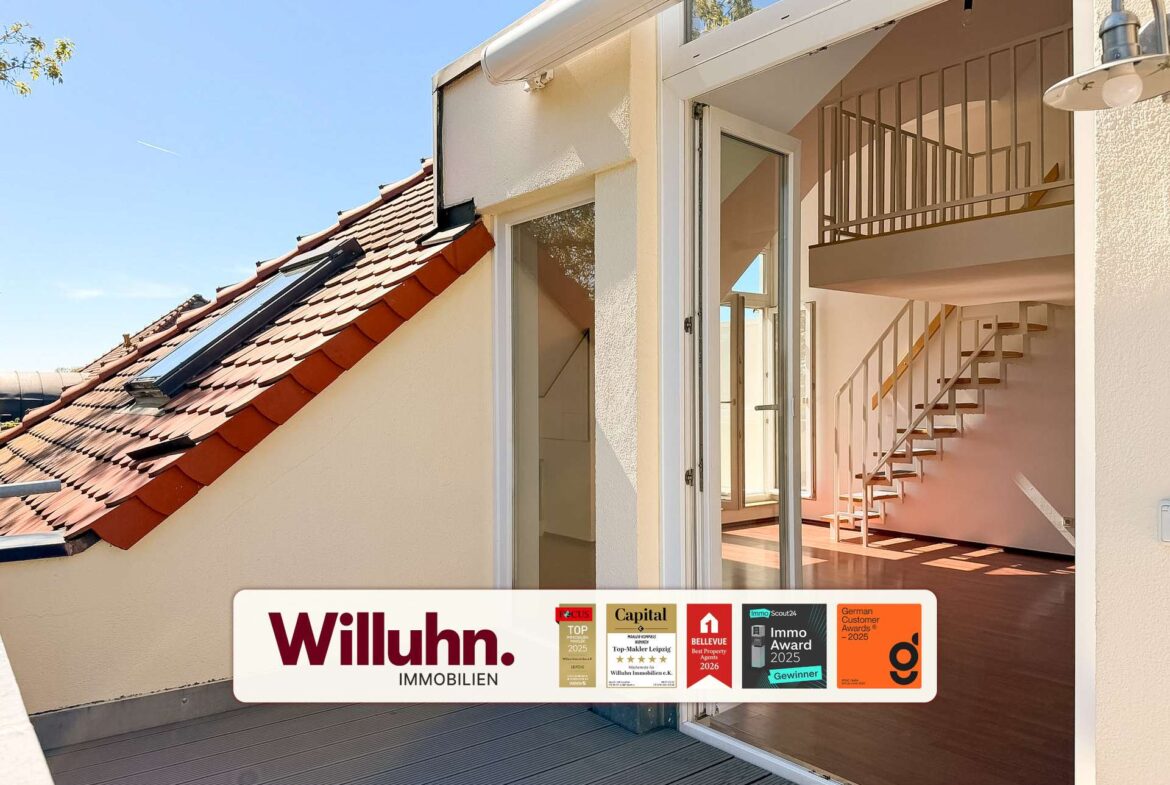 Open sliding glass doors into a modern interior with a metal staircase, and a Willuhn Immobilien real estate sign visible outside the doorway.