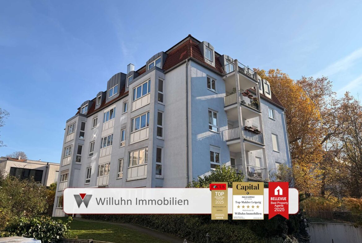 Five-story apartment building with blue and white facade under a clear sky; promotional banners for real estate agency at the bottom.