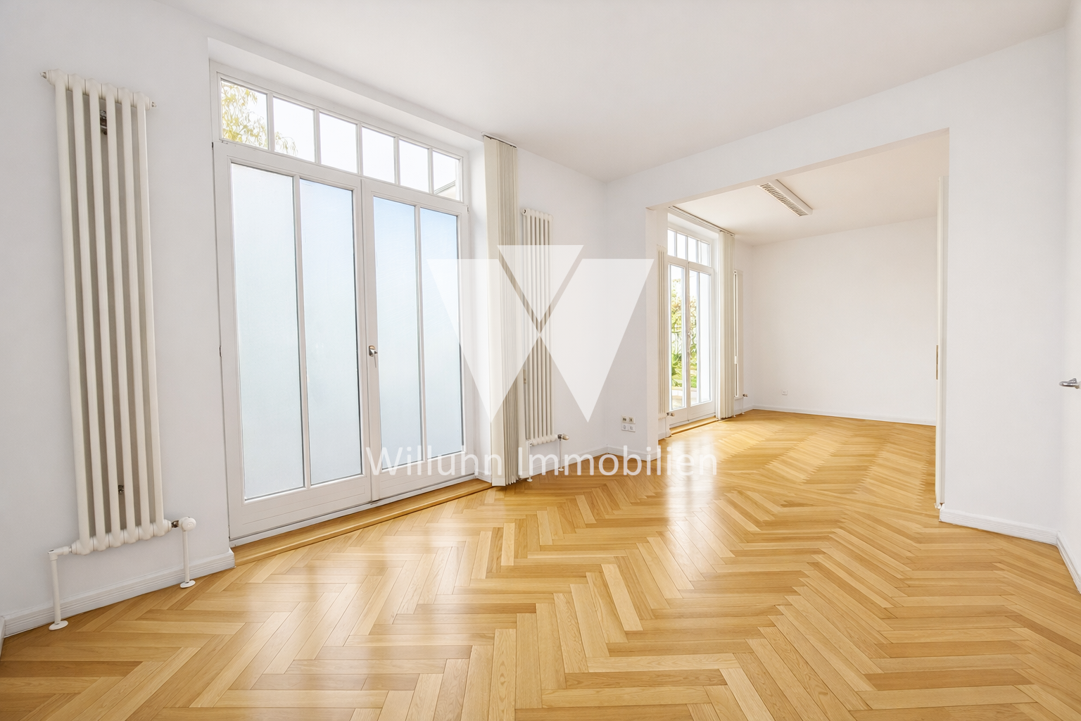 Bright empty living room with white walls, large frosted glass doors, and a herringbone wooden floor.