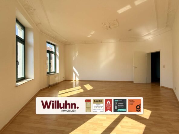 Bright empty room with tall green-framed windows, light wood floor, and decorative ceiling molding; doorway on the right.