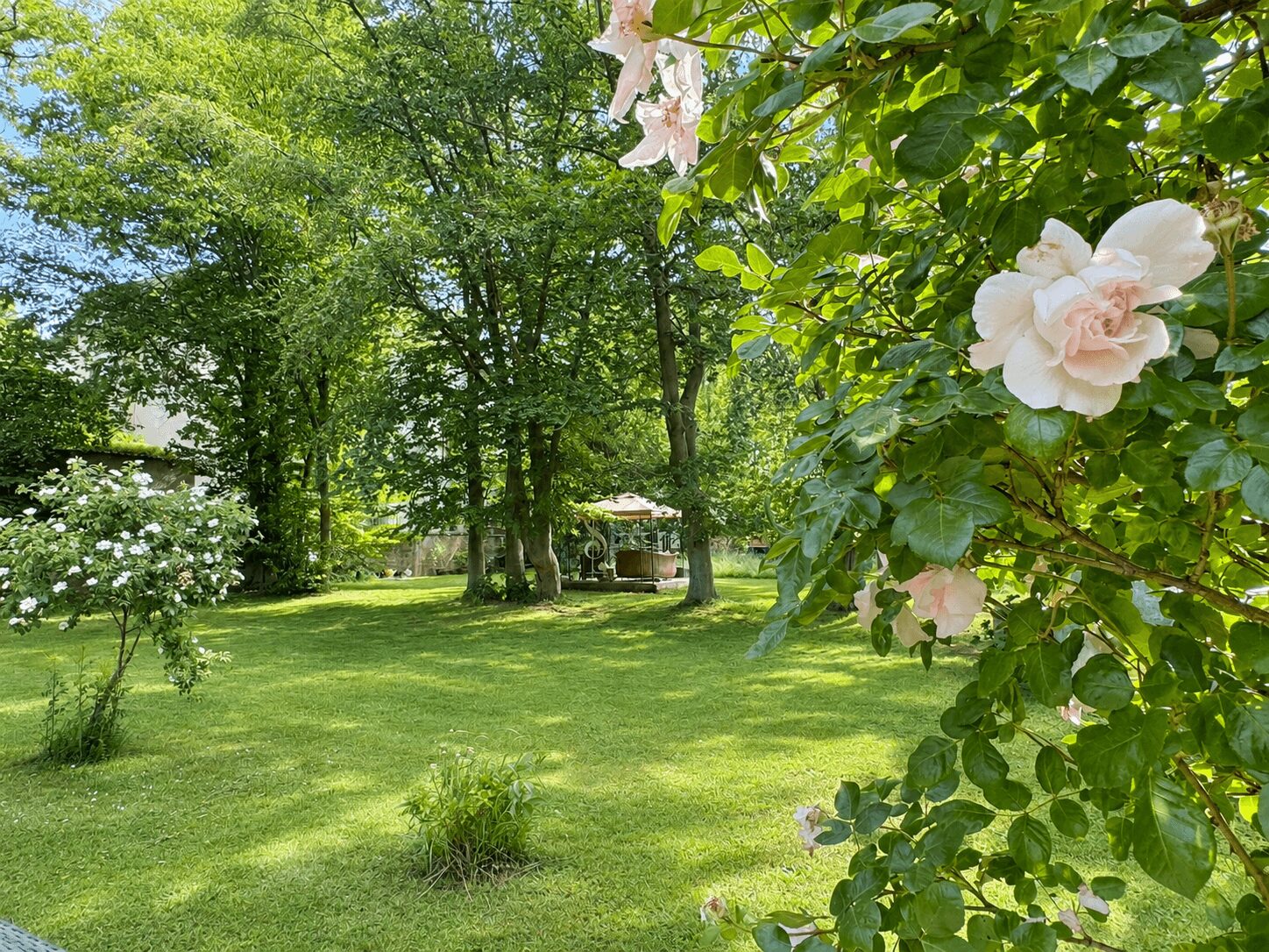Friedlicher Garten mit Rosen und Pavillon