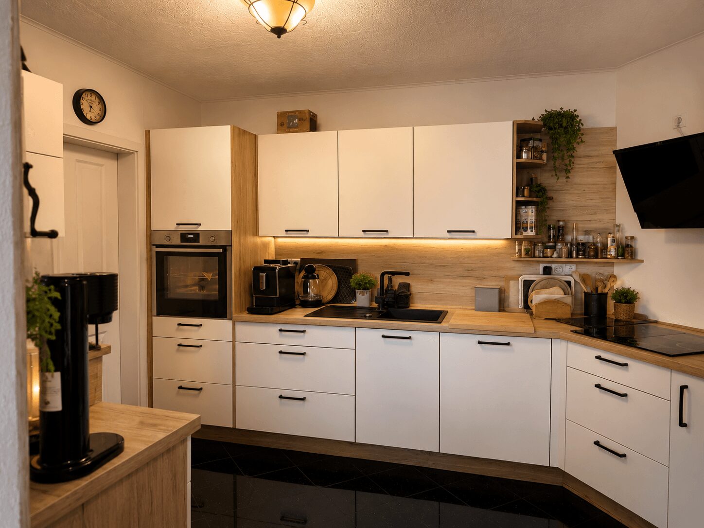 Modern kitchen with white cabinets, wooden countertops, built-in oven, and a coffee station along the counter edge.