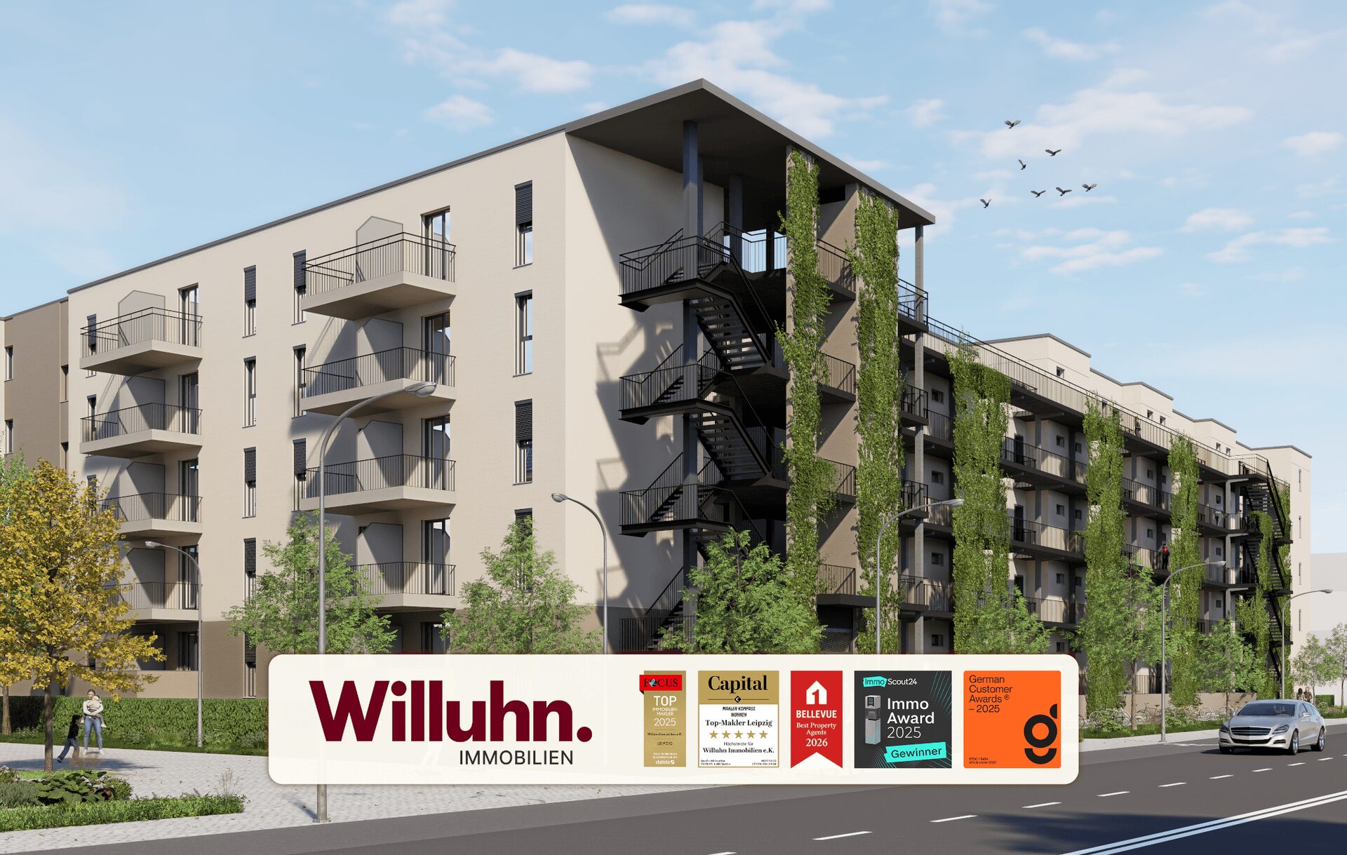 Modern beige apartment building with balconies and climbing greenery; a large Willuhn Immobilien sign with awards in front on the street side.