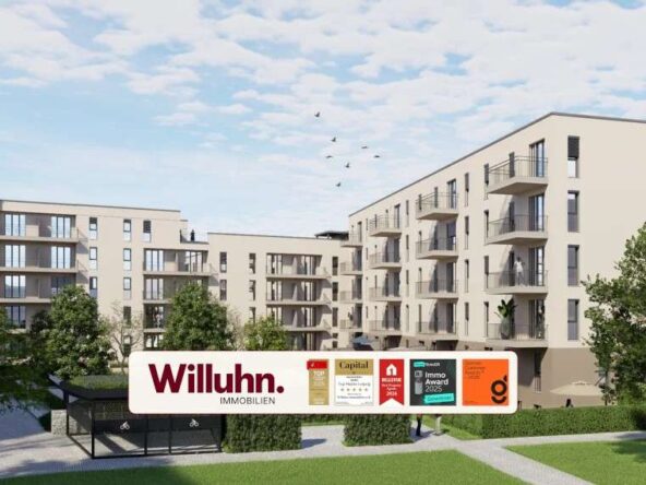 Modern beige apartment complex with multiple balconies and a grassy courtyard; foreground shows a large Willuhn Immobilien sign.