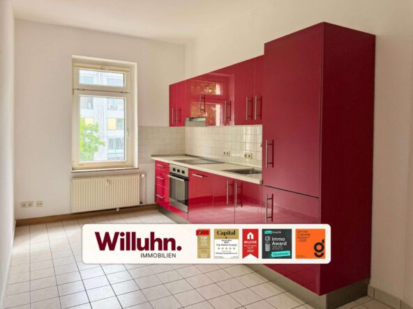 Modern kitchen with tall glossy red cabinets, white tile backsplash, and built-in oven beneath the stove. A window and radiator are on the left side.