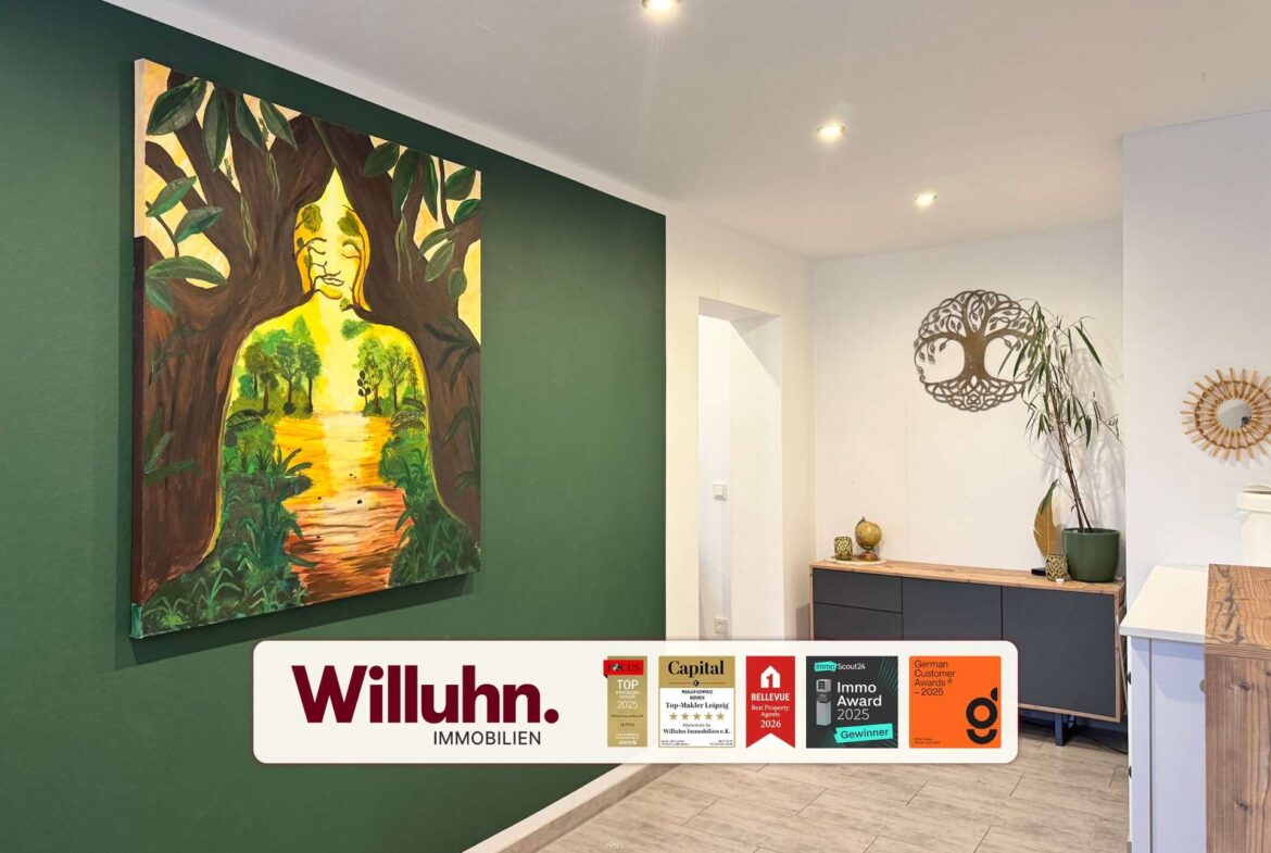 Interior showroom with a tall green accent wall and a large vibrant painting featuring a tree motif and a human silhouette beneath the branches.
