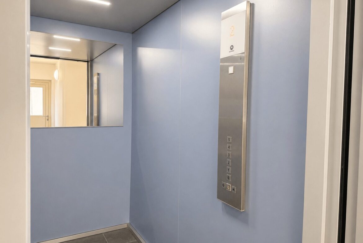 Elevator interior with light blue walls, a mirrored wall, and a stainless vertical control panel showing floor buttons 0–5.