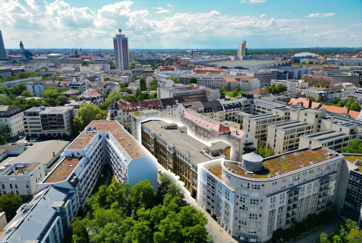 Aerial view of a dense cityscape with white modern apartment blocks, green trees, and a bright blue sky with scattered clouds.”,