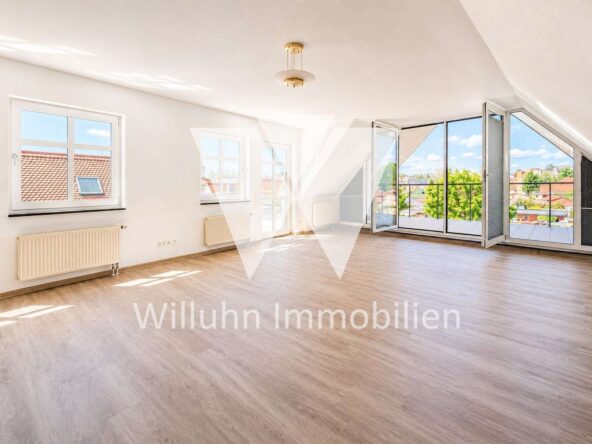 Bright empty living room with large glass doors to a balcony and a city view.