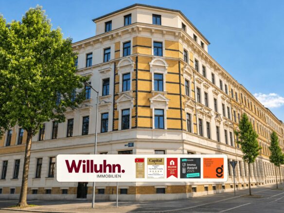 Corner building with yellow brick and white decorative trim on a sunny street; large Willuhn Immobilien banner along the sidewalk.