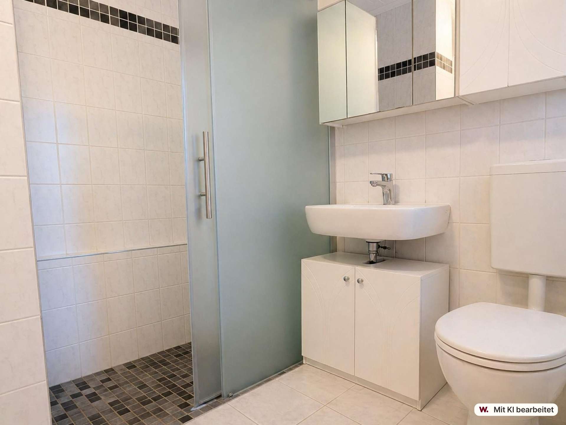 Modern bathroom with a frosted glass shower door, white sink on a cabinet, and mirrored medicine cabinet above.