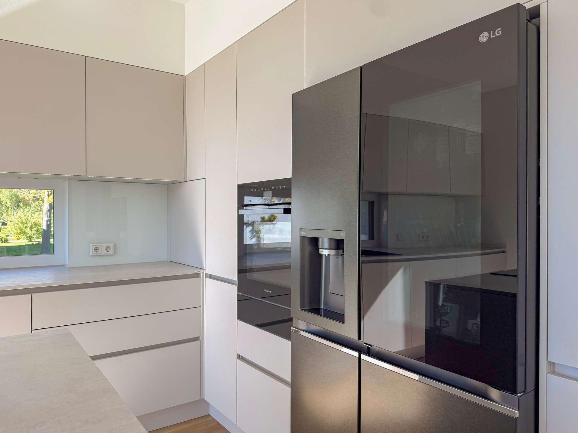 Modern kitchen with white cabinets and a large LG stainless steel refrigerator with a water/ice dispenser.