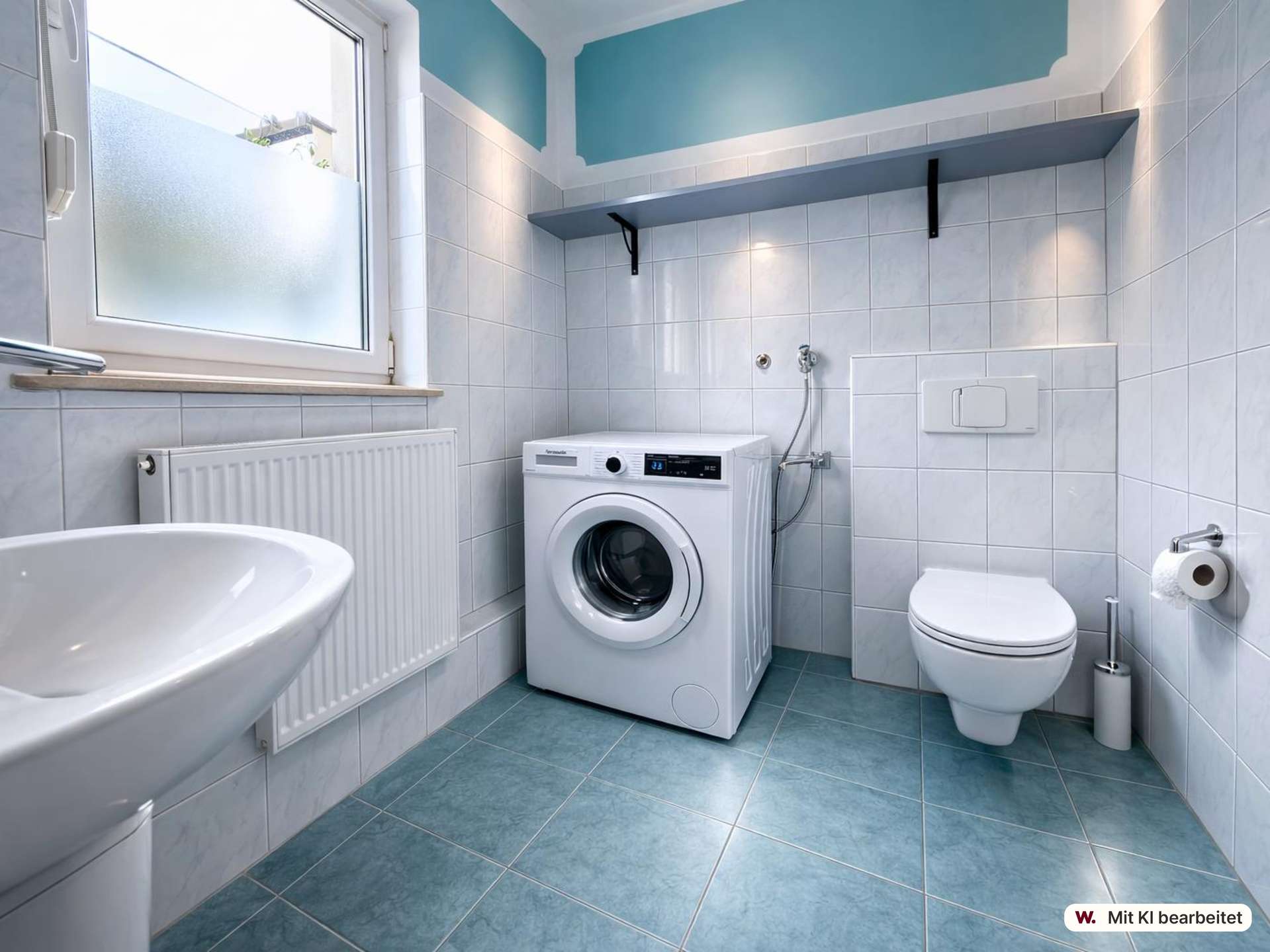 Bathroom featuring a front-loading washing machine next to a wall-hung toilet, sink, and frosted window with blue-tiled walls and floor.