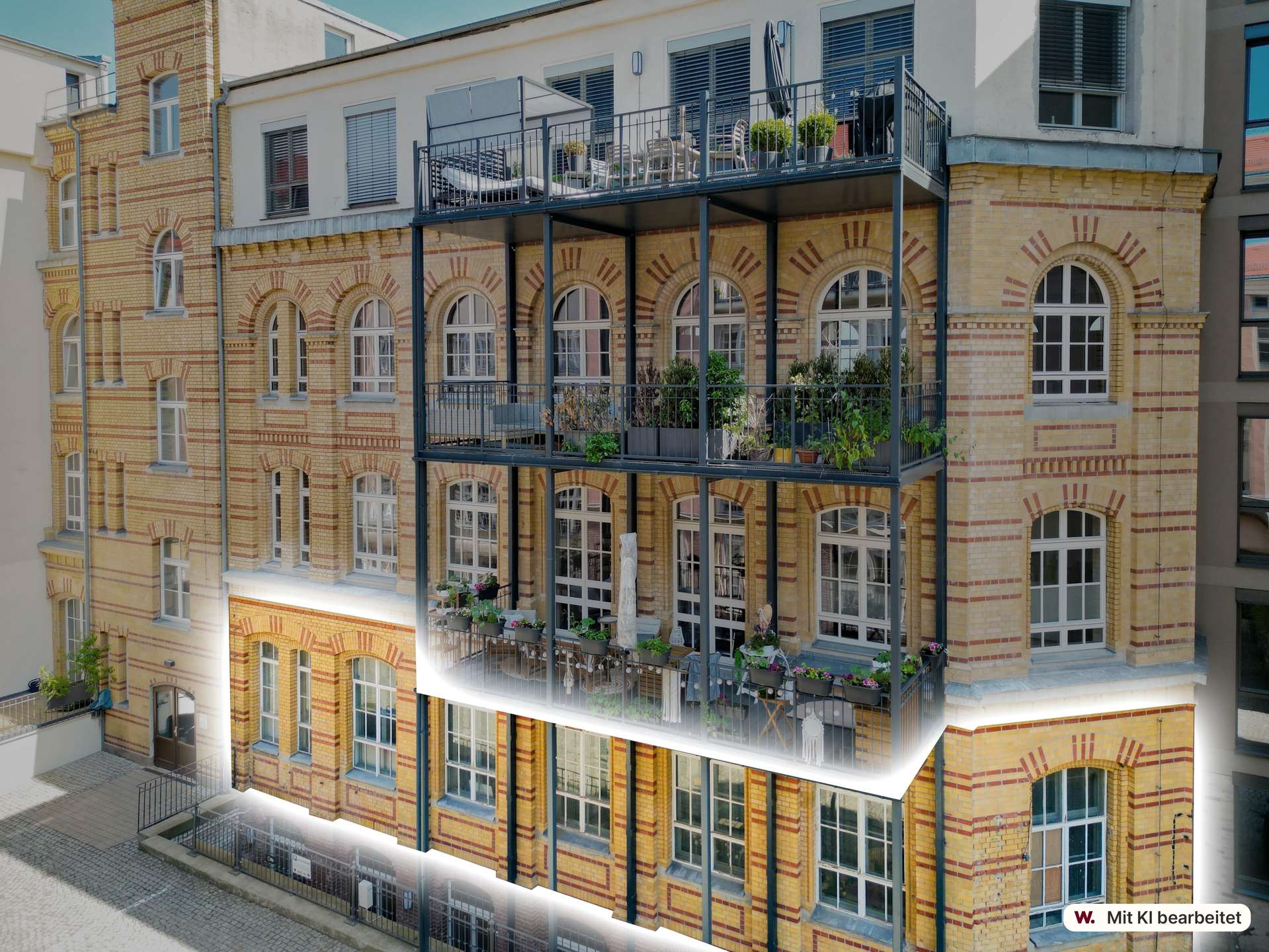 Brick apartment building with arched windows and a metal-framed balcony filled with chairs and potted plants on several levels