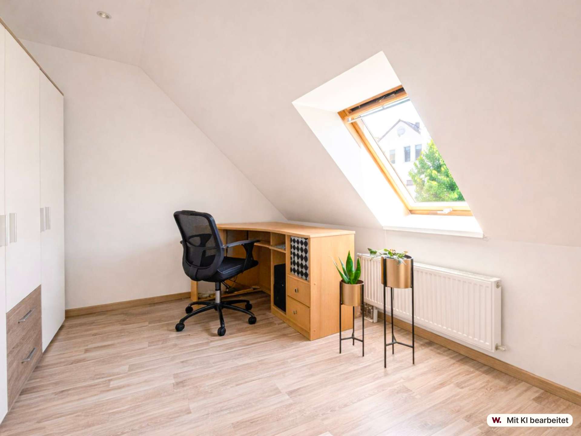 Home office under a sloped ceiling with a wooden desk, black ergonomic chair, and a skylight window.