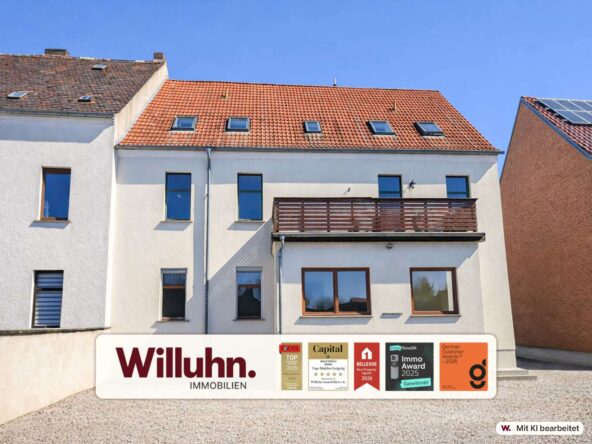 White apartment building with a red tile roof and skylights; a large Willuhn Immobilien banner with award logos is at the bottom.