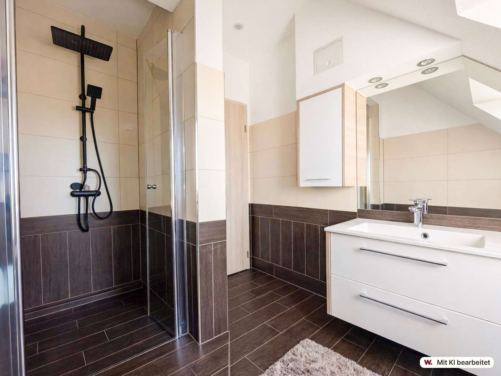 Modern bathroom with a glass shower enclosure, black wall-mounted shower system, white vanity, and beige-brown tiled walls and floor.
