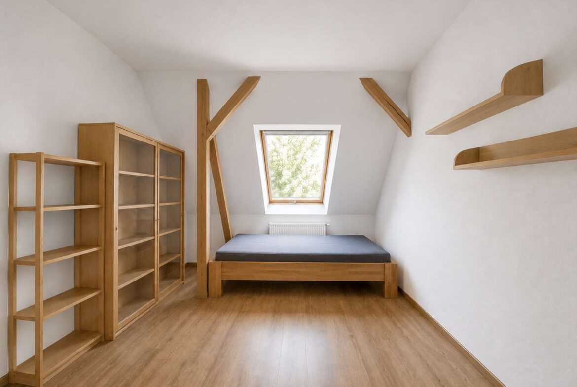Minimalist attic bedroom with wooden shelves, a glass-front cabinet, and a low bed under a sloped ceiling and skylight window for natural light.