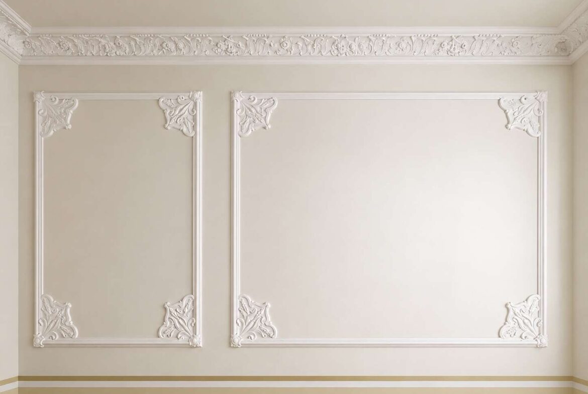 Beige interior wall with two large white decorative plaster panels and ornate corner motifs, crown molding above.