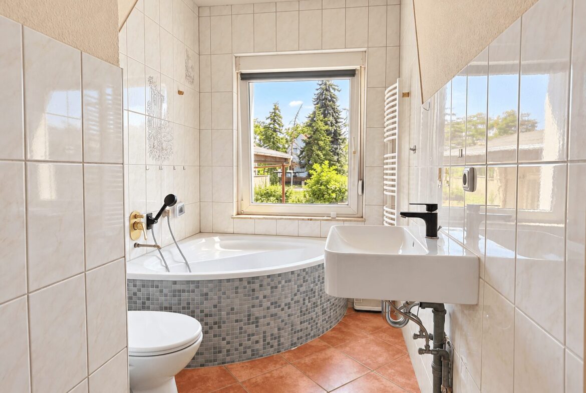 Badezimmer mit Fenster und Badewanne